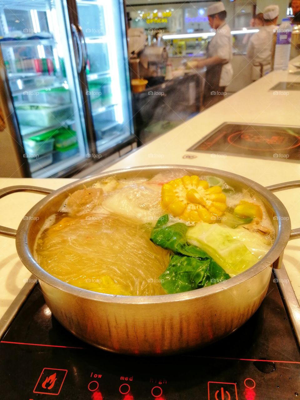 Steaming hot vegetable noodle soup freshly cooked in a restaurant.
