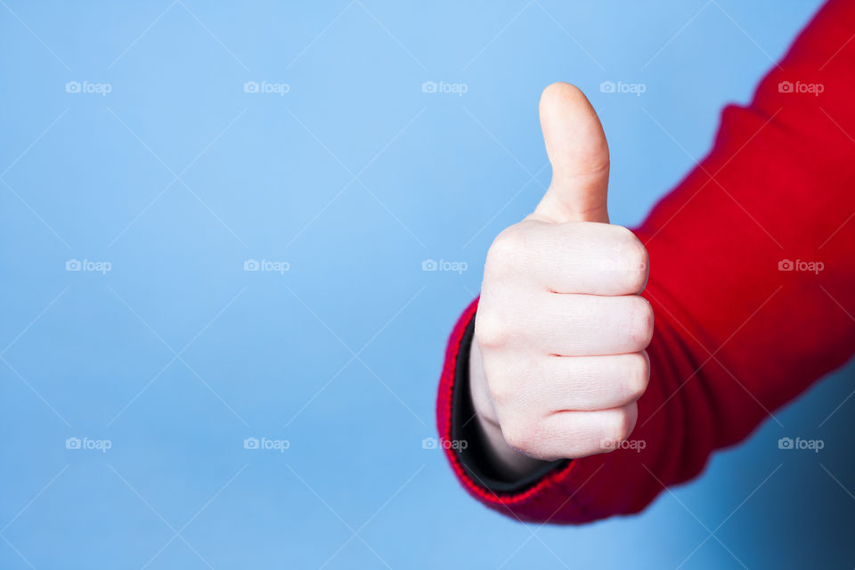 Female hand showing thumb up, success concept