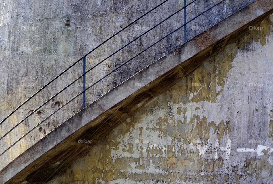 View of staircase railing at stone wall.