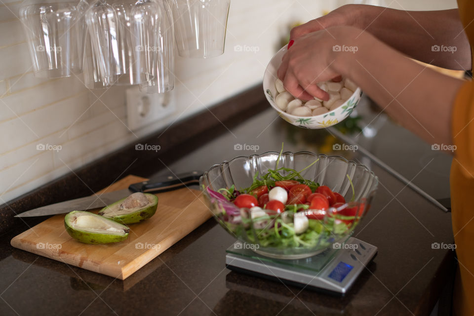 Preparing healthy food. Eating fresh vegetables.   Dieting. Mozzarella and cherry tomatoes salad. Food weighting.