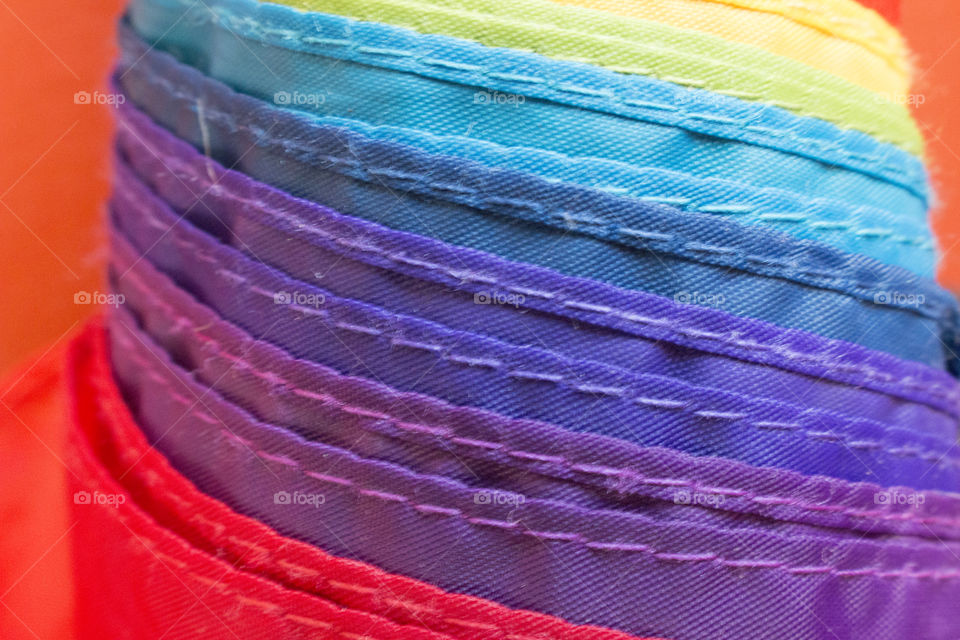 Rainbow colored umbrella fabric showing stitches 