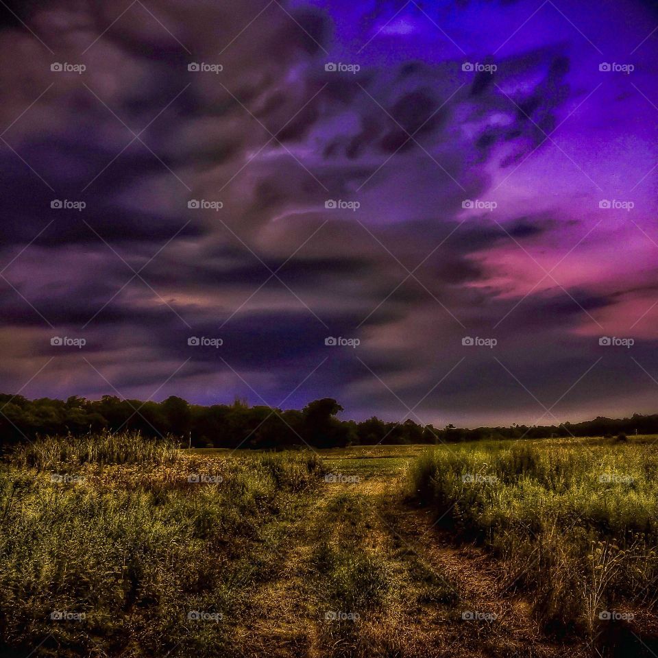 Dark, colorful skies. Storm clouds at sunset caused surreal-looking clouds over the farm 