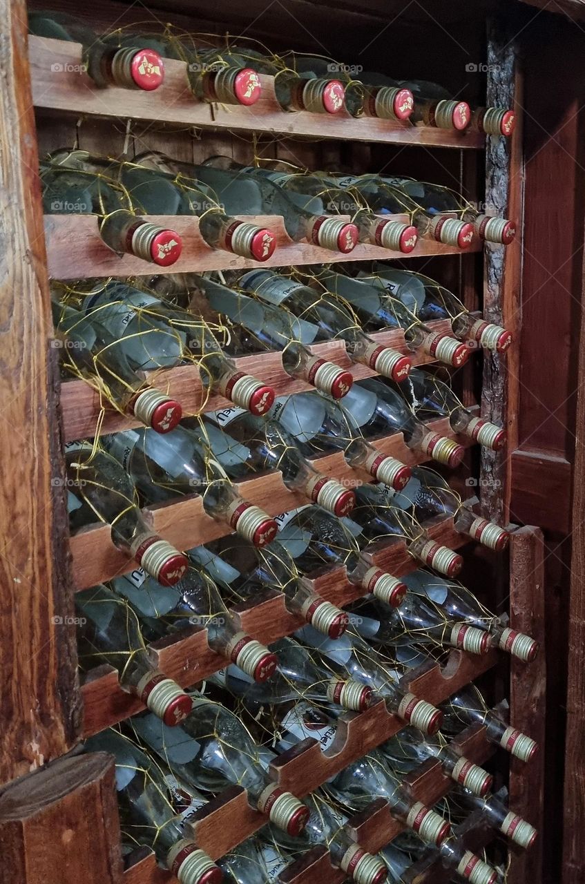 bottles and circular caps in a wine rack