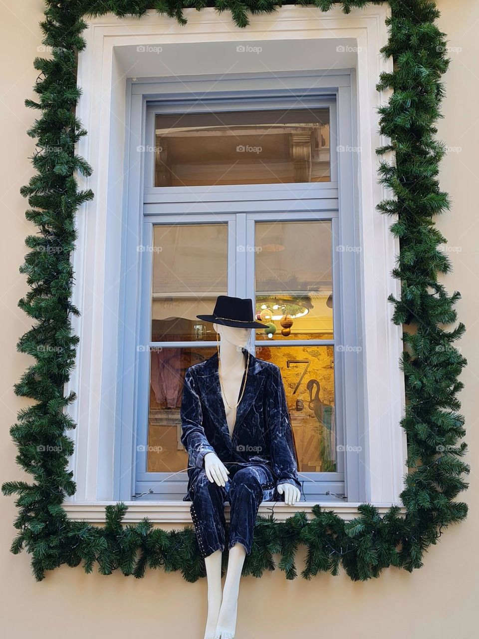 mannequin in hat sitting on shop window