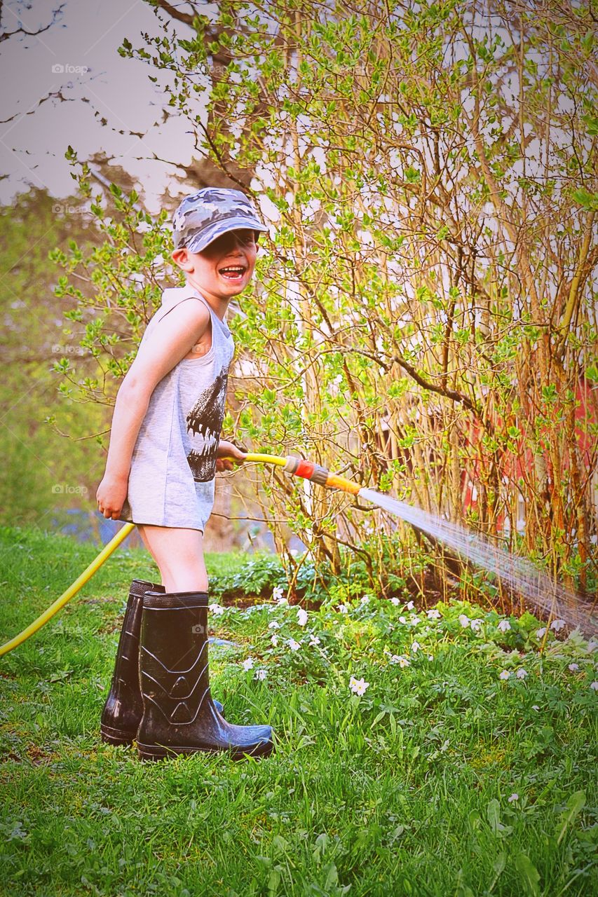 Boy watering flowers