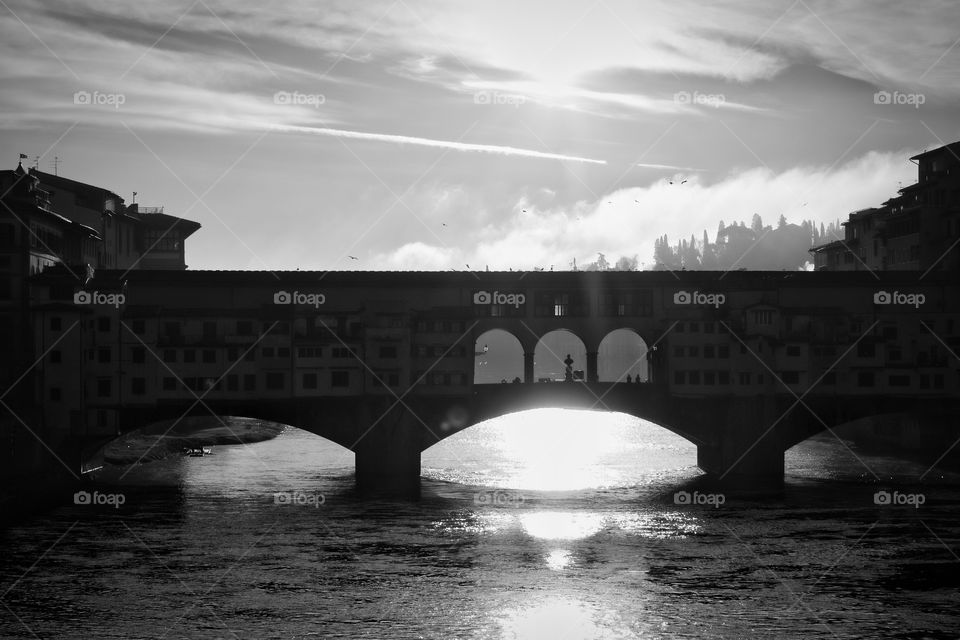 Sun rising behind the ponte vecchio in Florence Italy