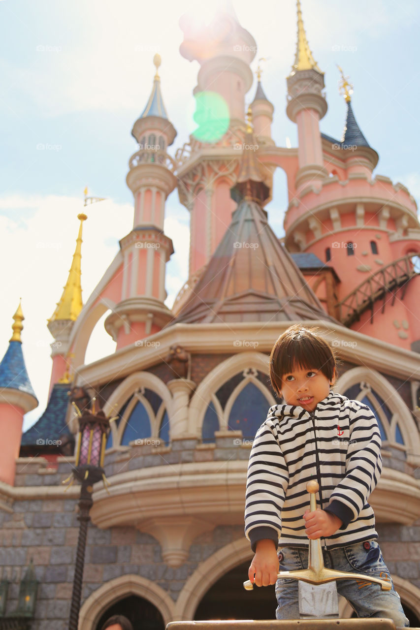 Young boy to be king. Thitiwin pulling the sword fron the stone at Disney land