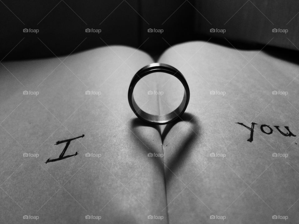Ring with heart shape shadow on book