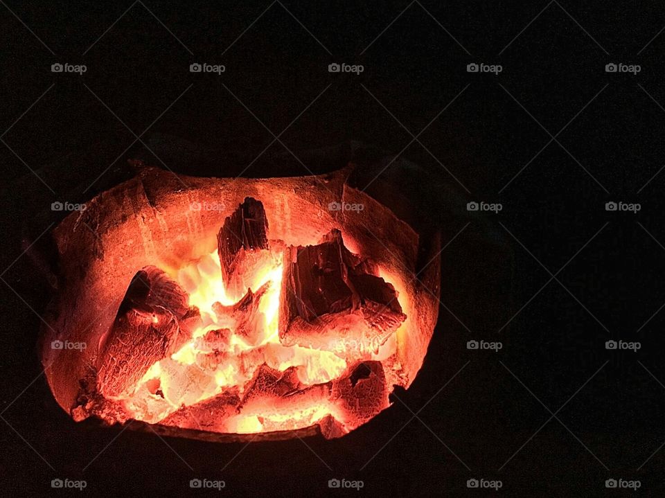 Fiery fire in a charcoal stove at night.