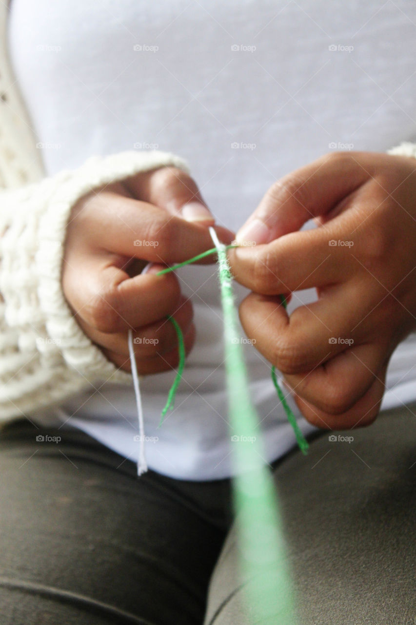 Person making friendship bracelet