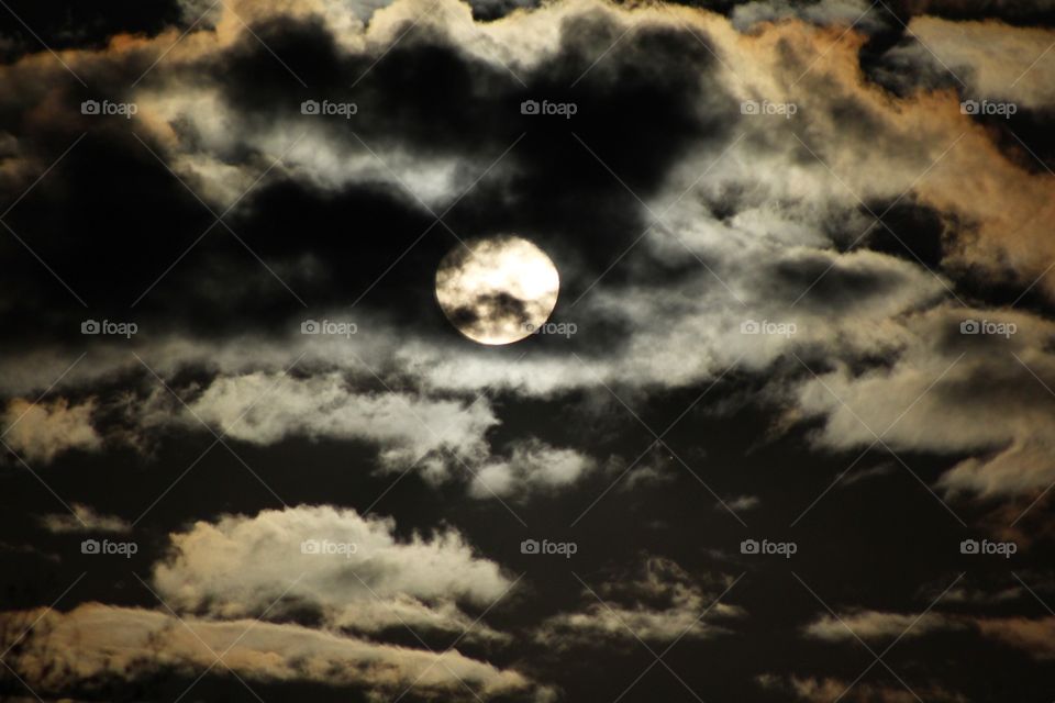 Storm clouds rolling over the full moon