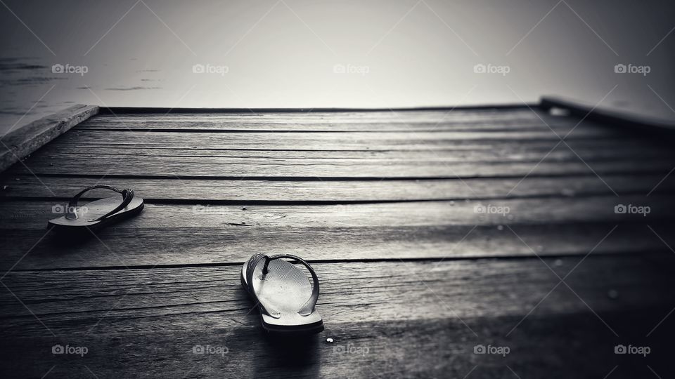 Old slippers on wooden pier