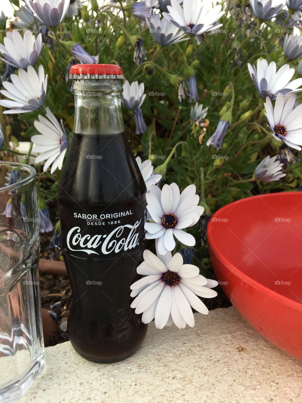 Coca-Cola with flowers from garden