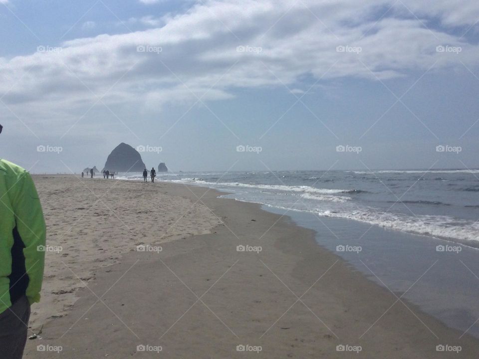 The White Sand Along Cannon Beach with People and the Rock Formations in the Distance 