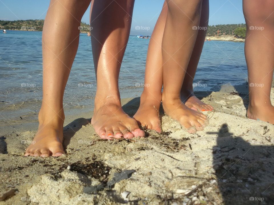 Legs of people on the beach