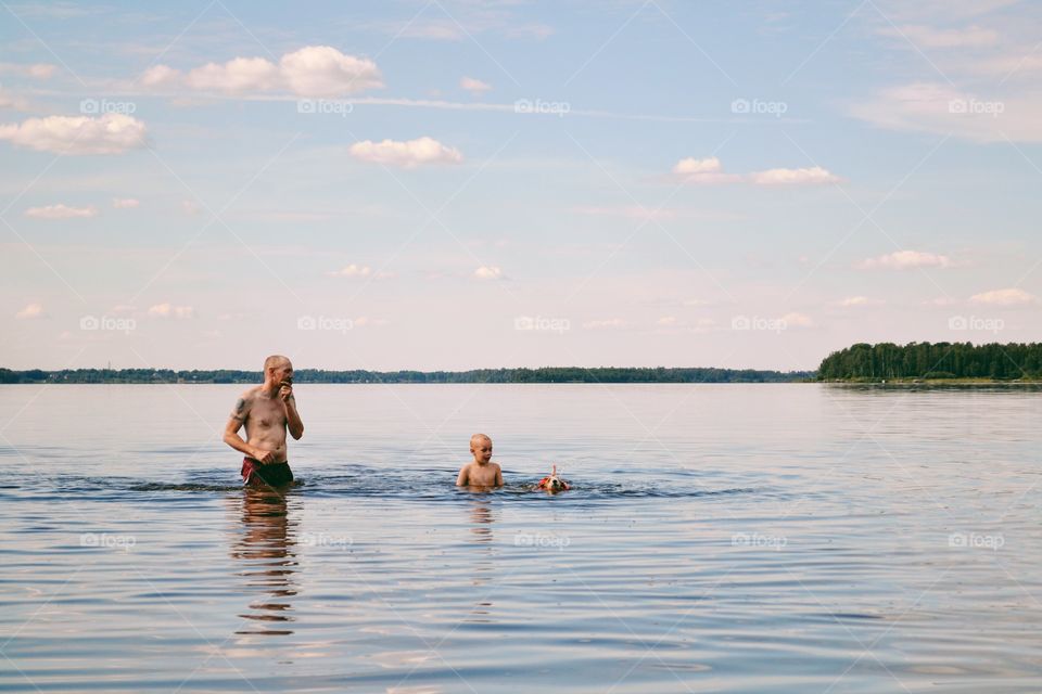 Father and son swimming in the lake