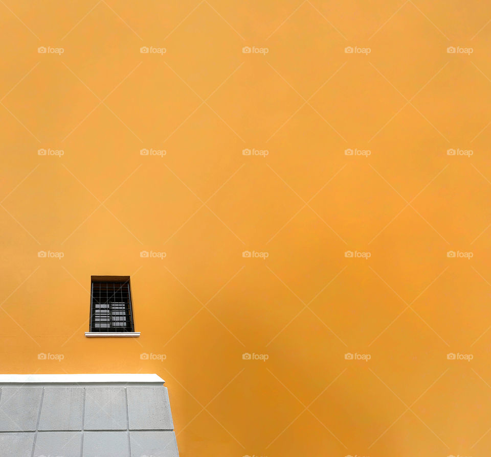 Minimalist facade of yellow building. Minimal architecture in Murcia, Spain, 2019.