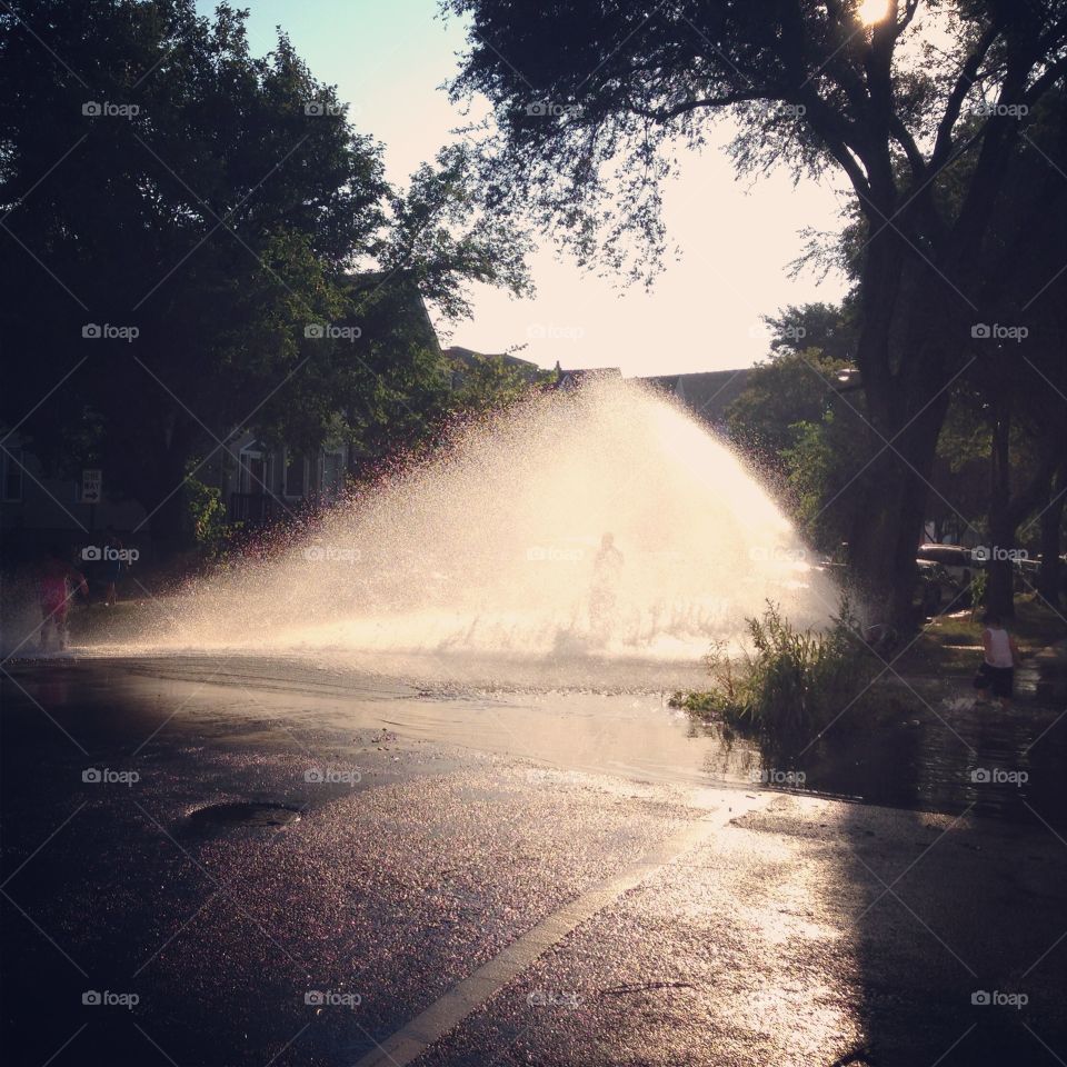 Water spray from fire hydrant on 100 degree summer day in Chicago 