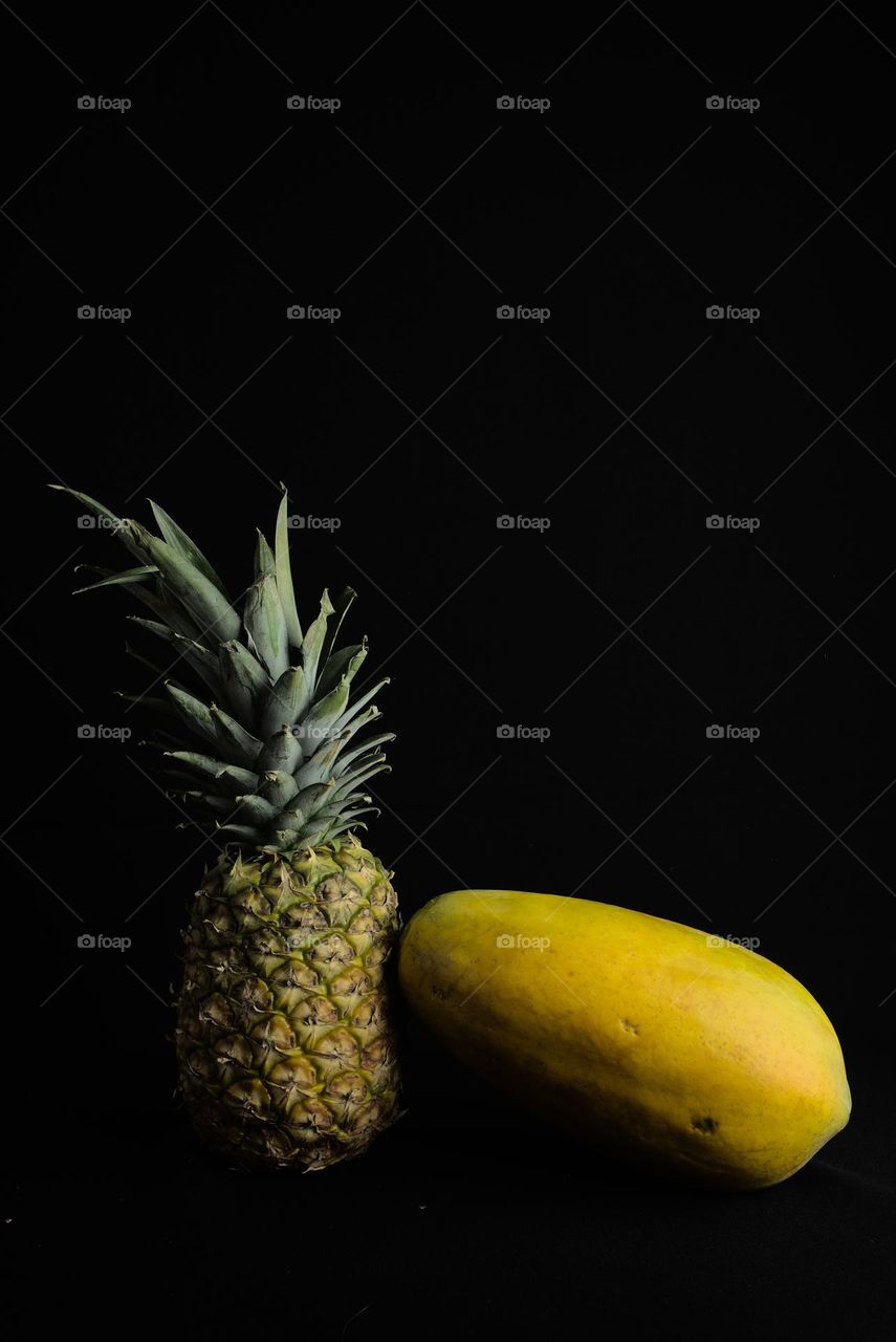 Pineapple and Papaya on black background. Tropical fruit