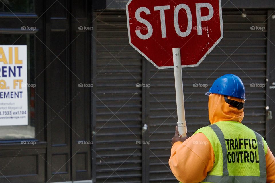 A traffic control person with “Stop Sign