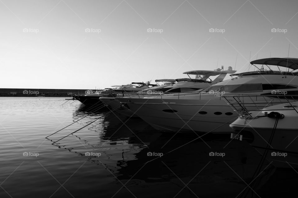A row of yachts at a quiet marina.