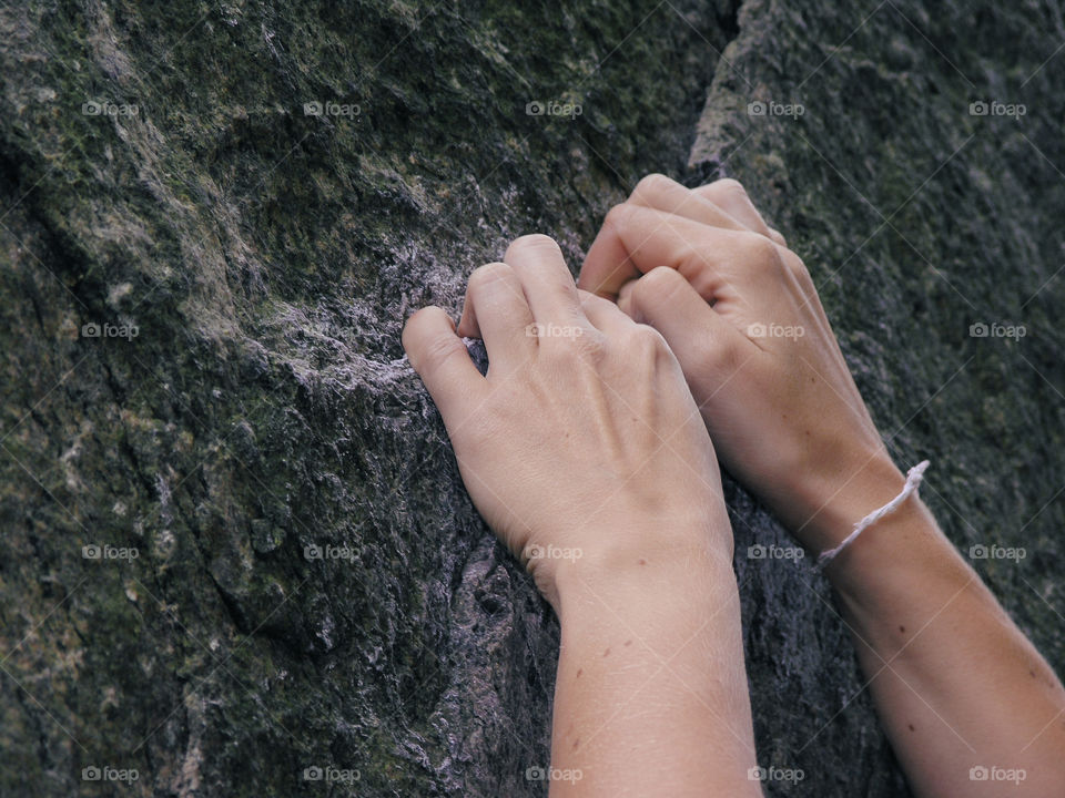 Close-up of climber's hands on cliff