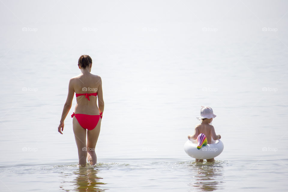 Mother and little daughter in the water