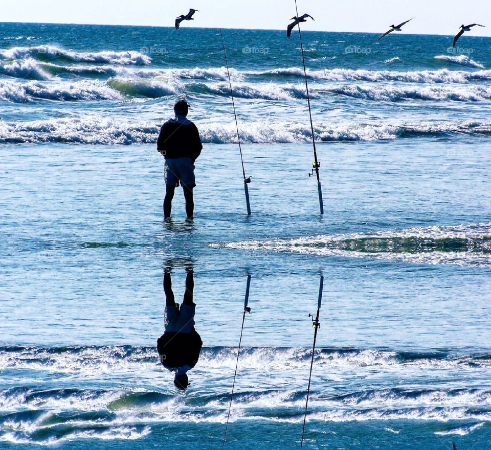 foap mission world of silhouettes and shadows man fishing on beach pelicans flying overhead mirrored image