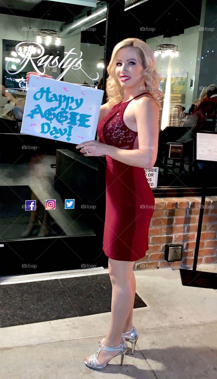 Me, holding up the sign that my friend made me on my birthday when we went out.