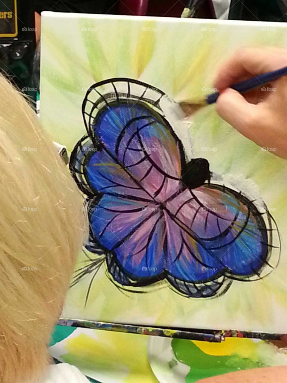 woman painting picture of a butterfly