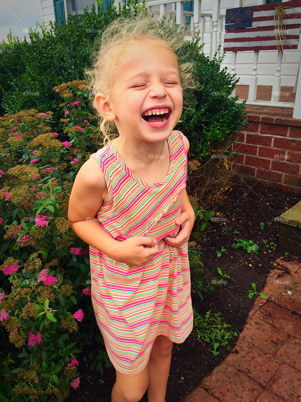 Portrait of a little girl standing near the flowering plant