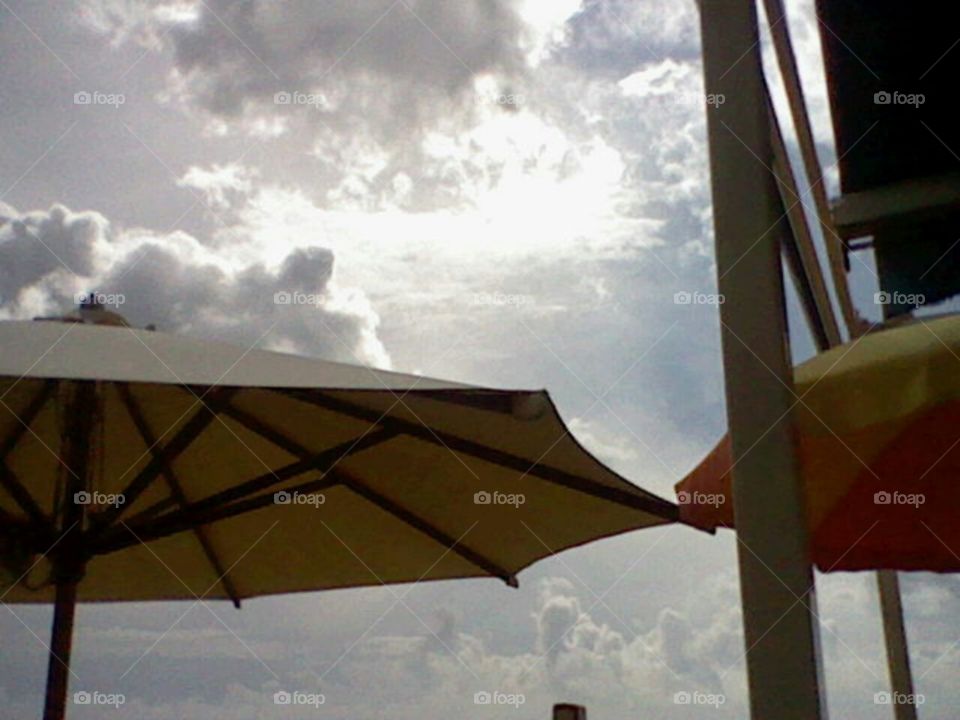 Sonnenschirme zum Schutz vor grellen Strahlen, ein kleines Unwetter zieht auf , die Wolken lassen es ahnen