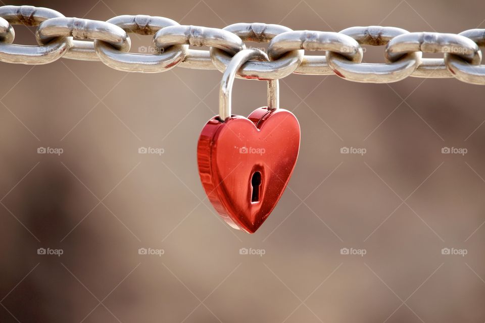Love, Red heart shaped padlock hanging on a steel chain - Kärlek , rött hänglås format som ett hjärta hänger på en kedja gjord i metall 