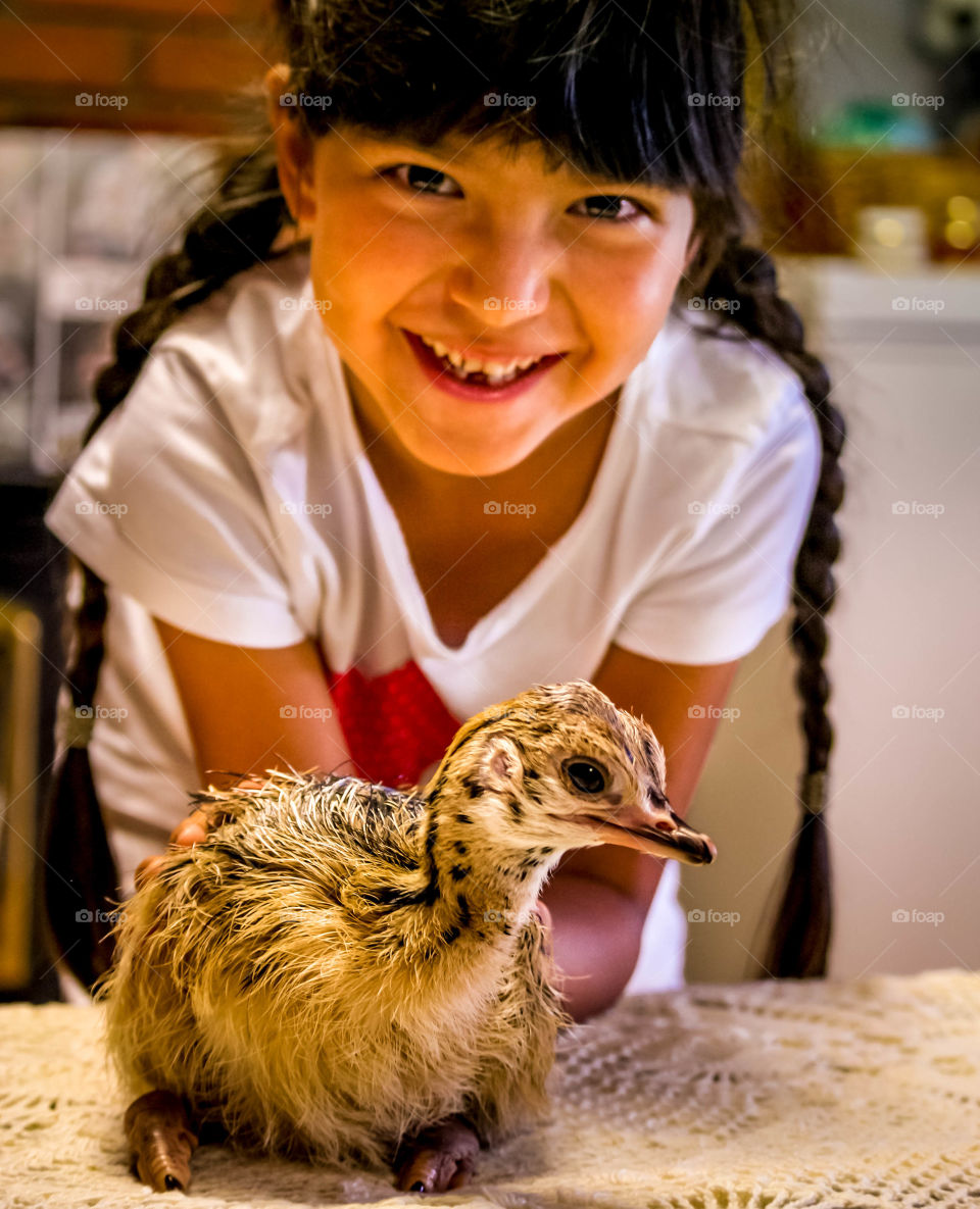Happy little girl and baby ostrich