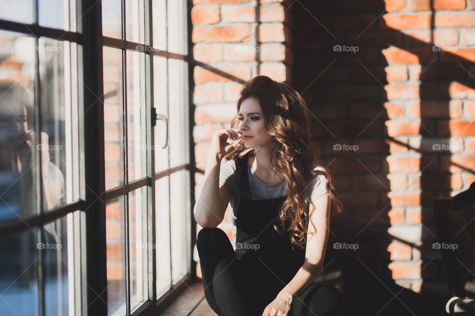 Portrait of young beautiful woman near window