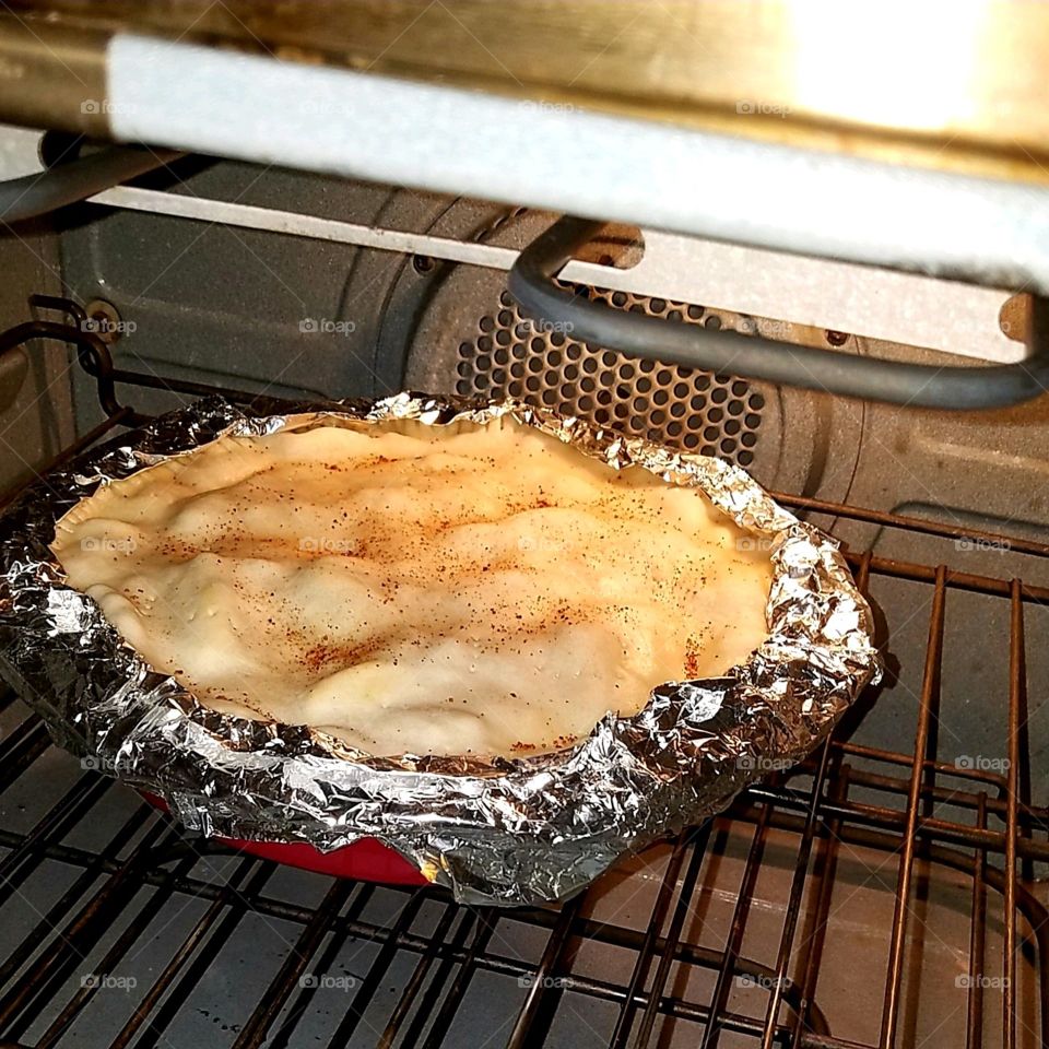 Apple Pie in oven, done & ready to take out. Aluminum foil on crust to keep from burning. Everything is homemade.