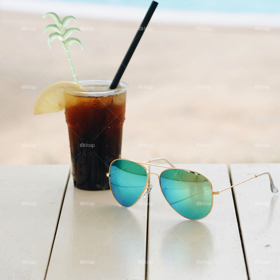 Close-up of sunglasses and cocktail