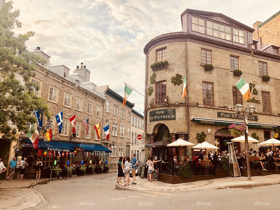 Many flags and an irish pub in french colonial buildings on the streets on Quebec city