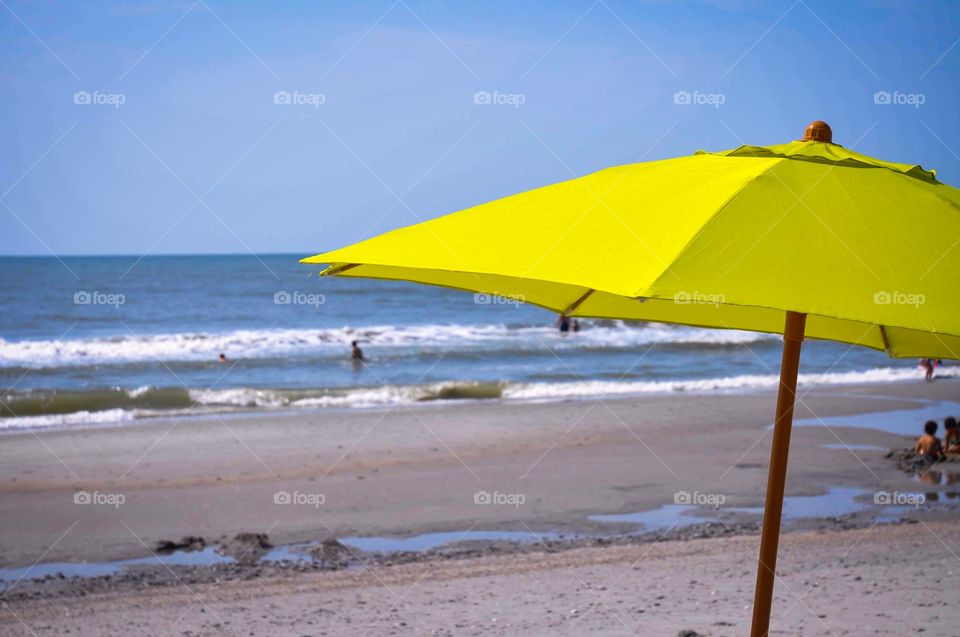 A perfect at the beach. Yellow beach umbrella at the seashore.