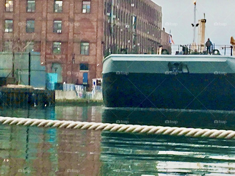 The back end of a large barge that just passed by us on the waters of the East River at Newtown Creek in Long Island City, Queens, NY is still visible when this photo was taken in late 2021. Hypnotic Productions