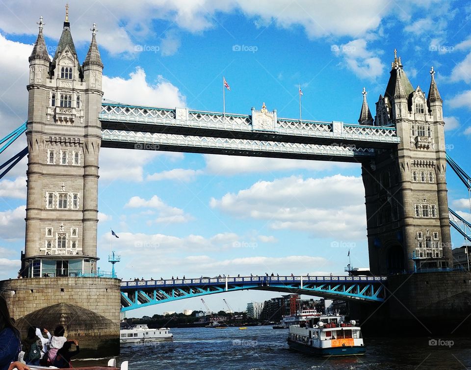 view of iconic tower bridge in london from the water on sunny day