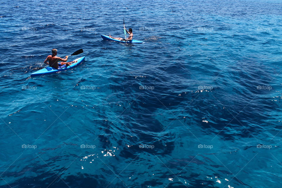 Two people kayaking in the Blue Lagoon in Ayia Napa, Cyprus during summer on a sunny day