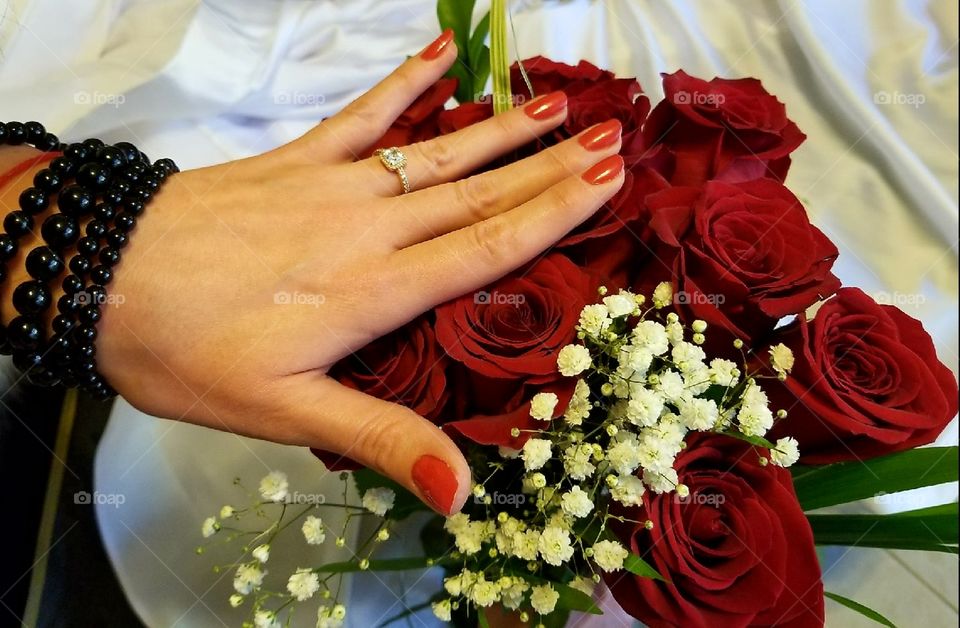 Engagement ring on red roses
