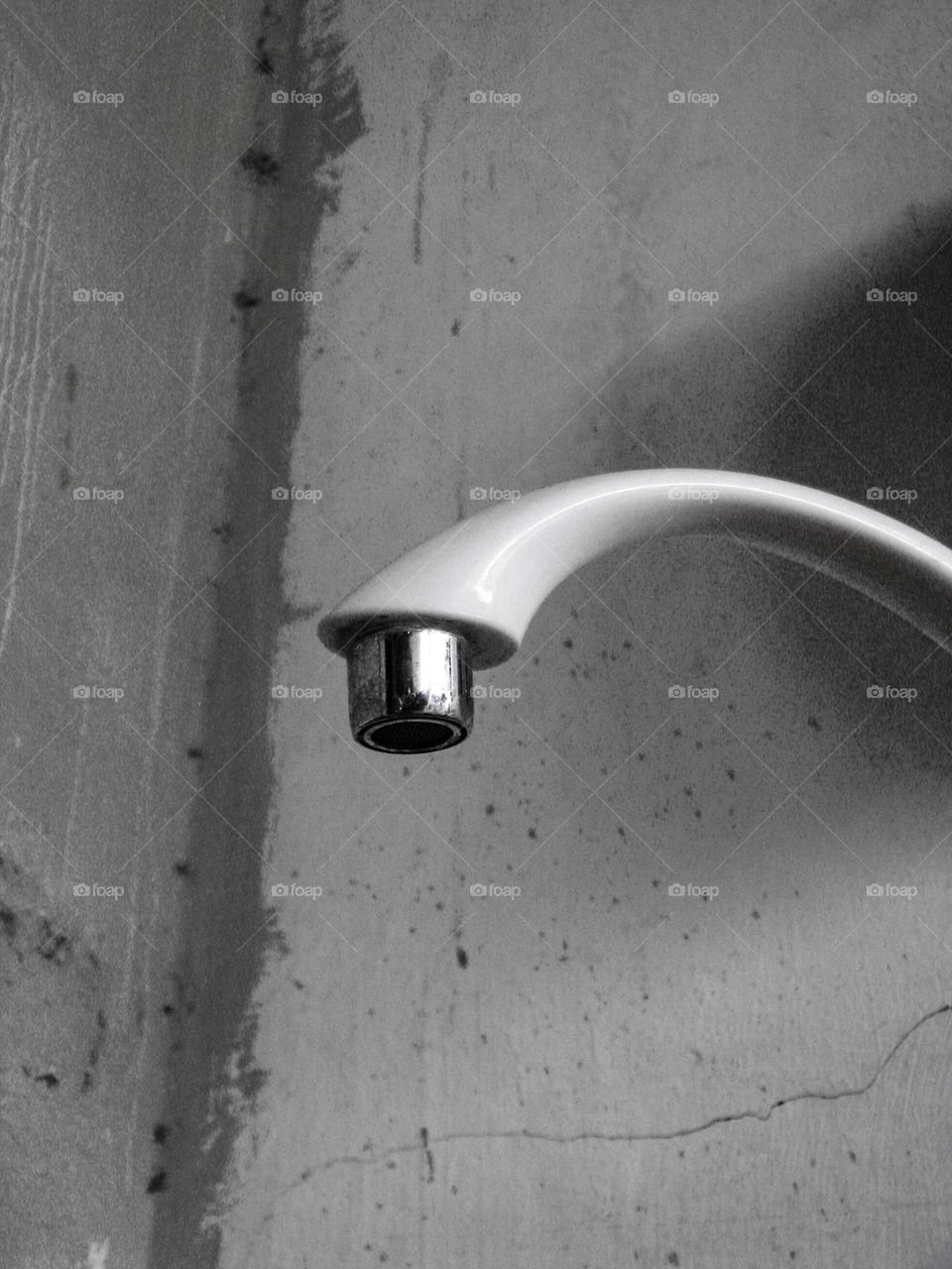 a bathroom wall-mounted shower head that looks old or worn