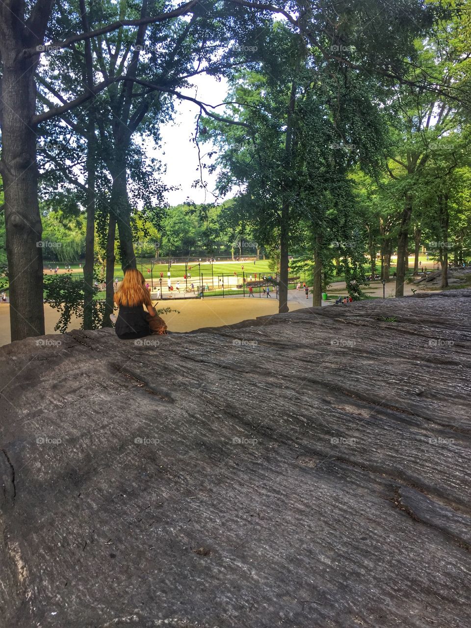 The Ballpark. A woman watching baseball in Central Park