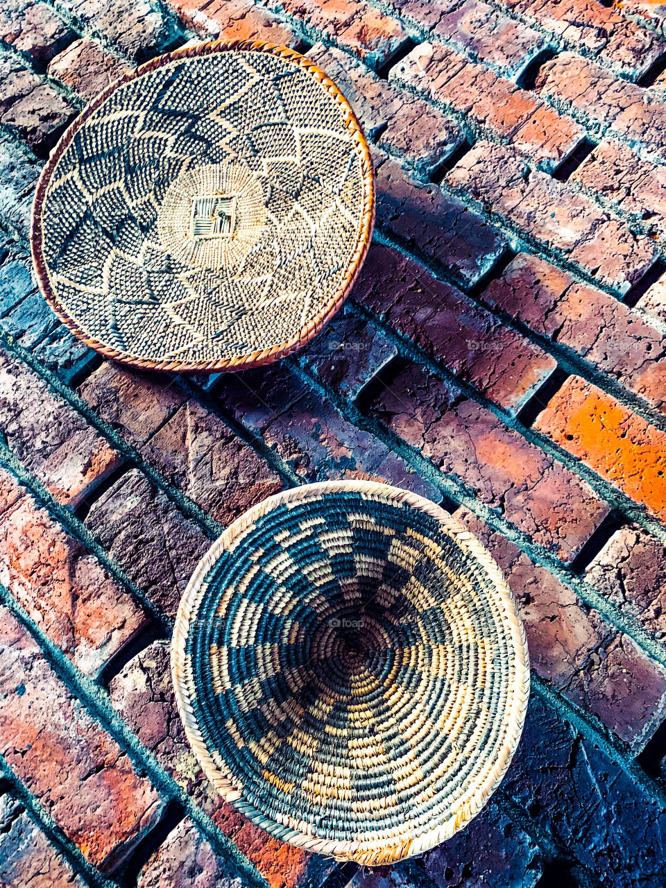 Finely coiled baskets hung on a brick as an ancient African theme on a brick wall in a restaurant. 