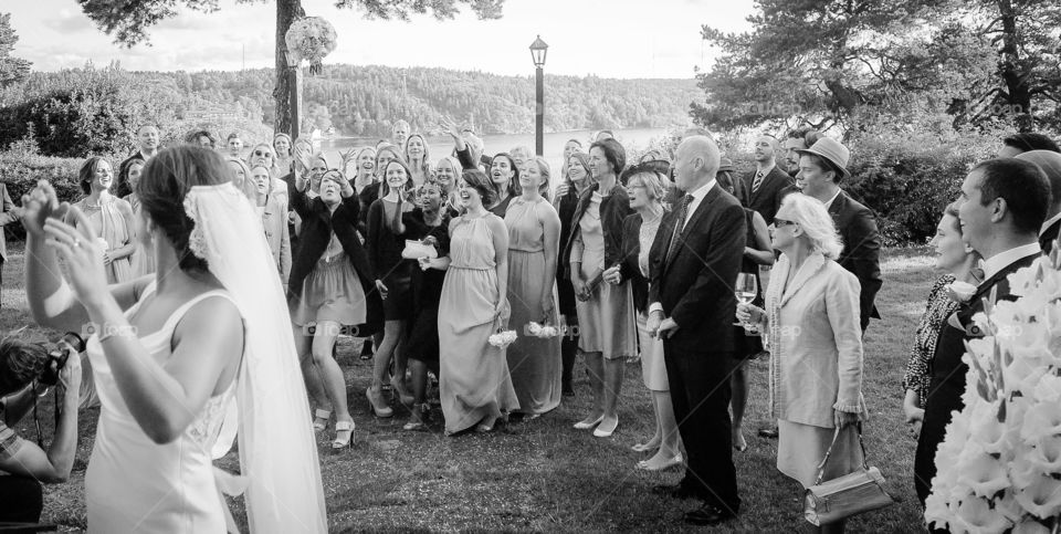 Bride throwing bouquet for guest to catch