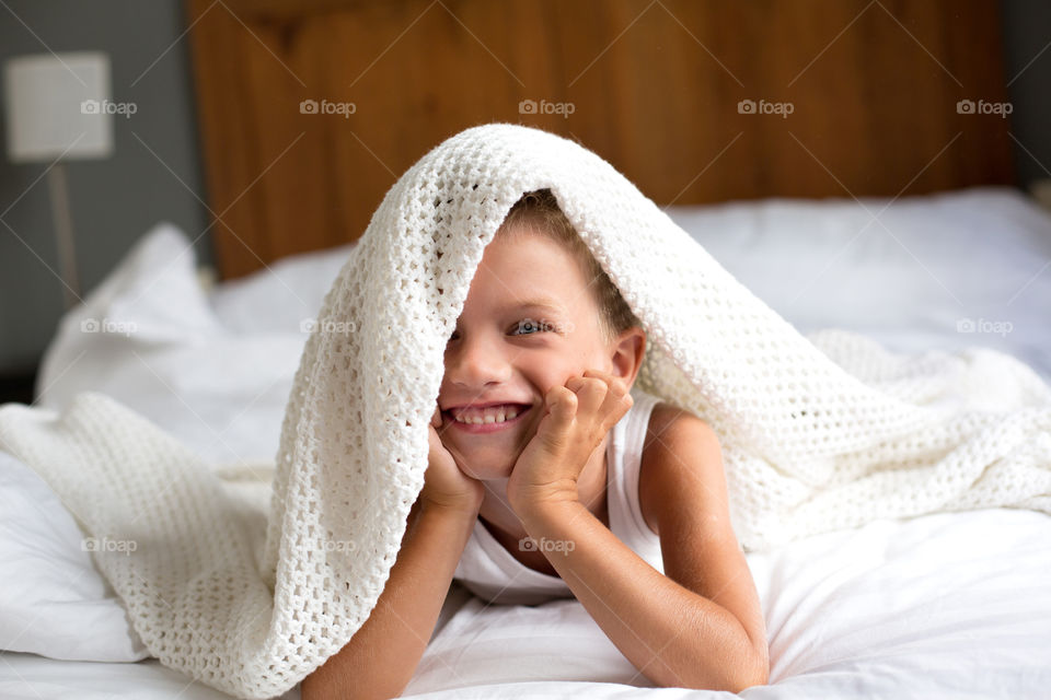 Smiling boy lying on bed