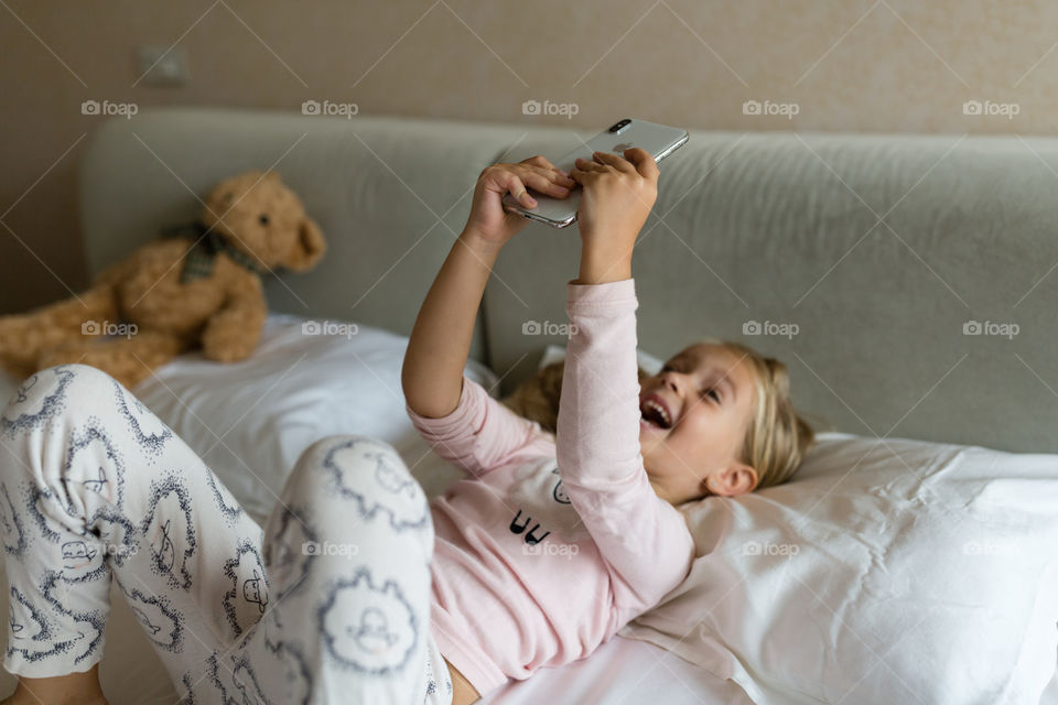 Cute little girl with blonde hair making selfie 