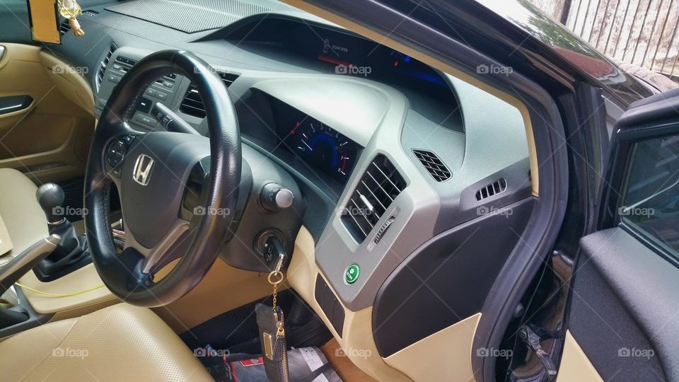 Car steering wheel, car ignition, car dashboard, car brand logo, manual transmission gearshift lever, indicator display, odometer, handbreak, audio button, ECO fuel savig button, AC vent, AC regulator